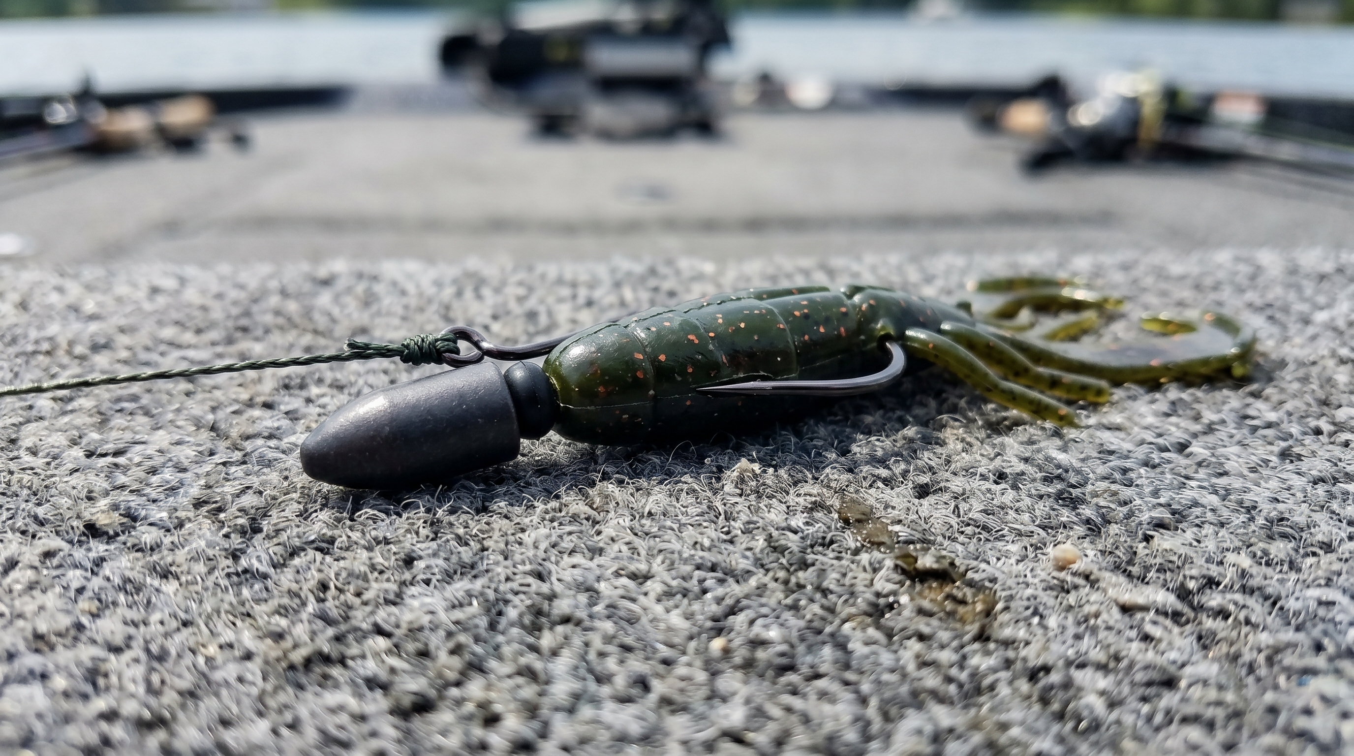 Texas-rigged green pumpkin creature bait on boat deck