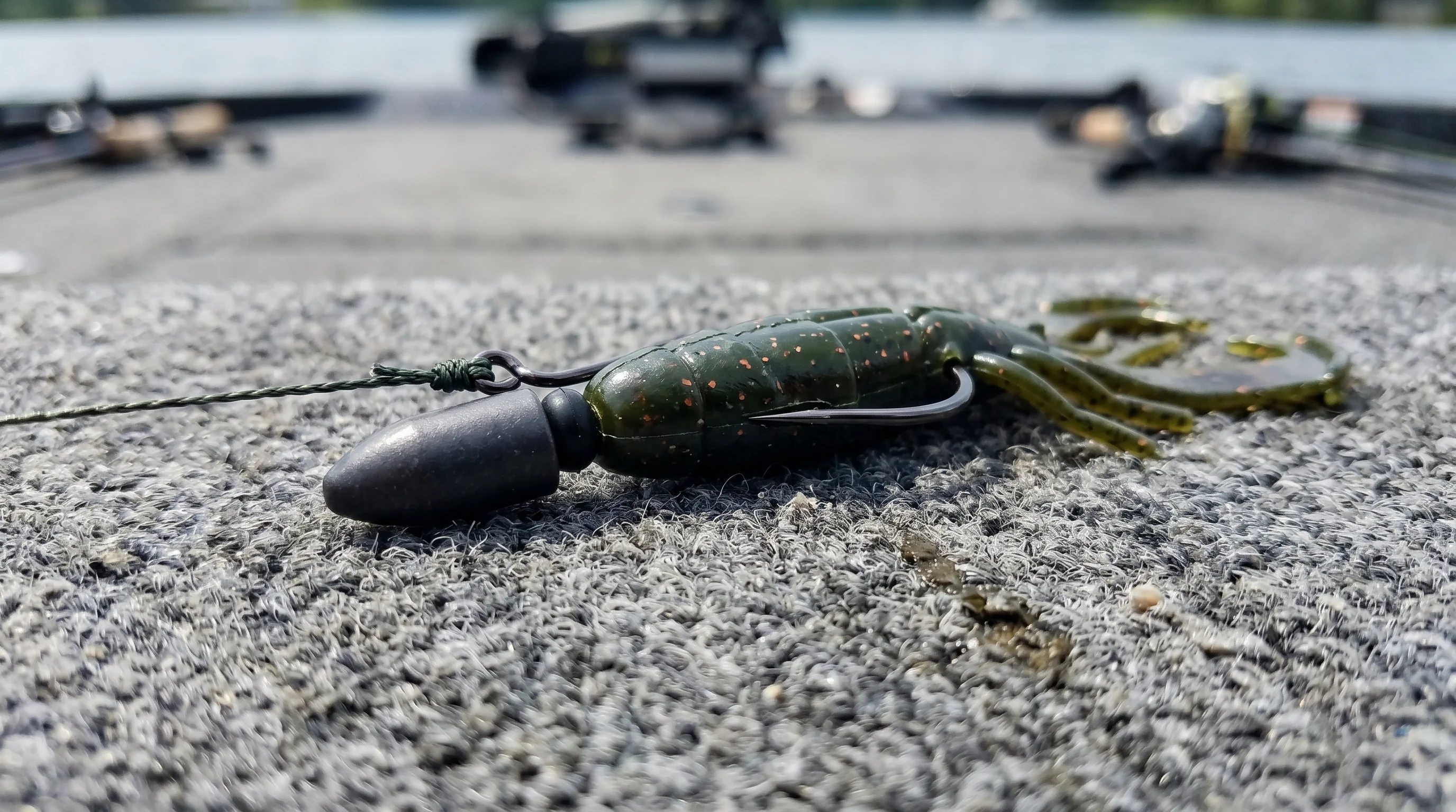 Texas-rigged green pumpkin creature bait on boat deck